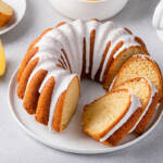 Lemon bundt cake sliced on a plate with powdered sugar glaze
